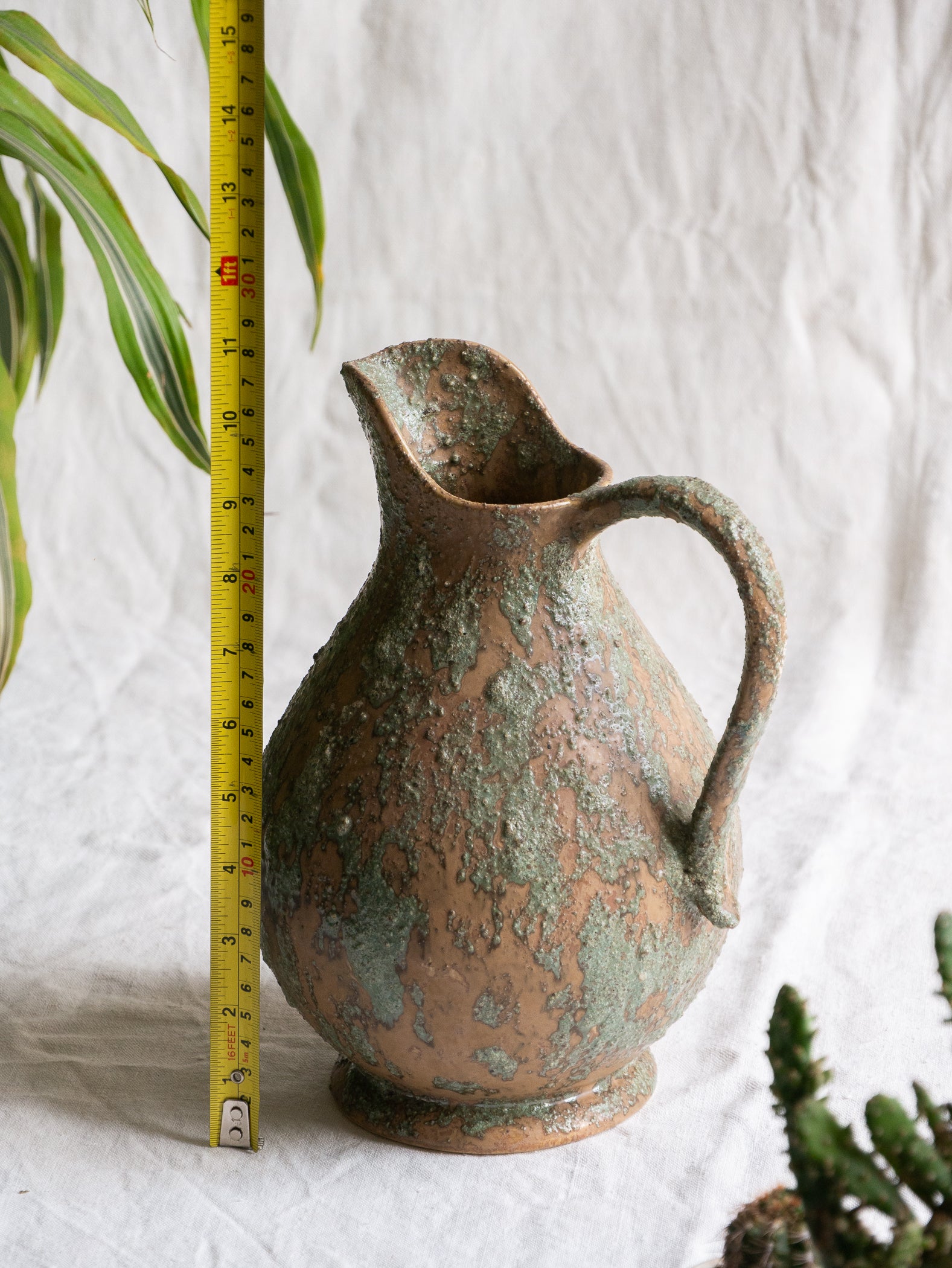 An artisan-made vintage pottery pitcher or jug that purchased in south west France. This piece is wonderful in its earthy tones of brown with a green pattern in relief all over the pitcher and would make a great piece of home decor or addition to a pottery/stoneware collection.