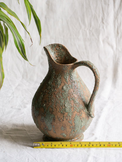 An artisan-made vintage pottery pitcher or jug that purchased in south west France. This piece is wonderful in its earthy tones of brown with a green pattern in relief all over the pitcher and would make a great piece of home decor or addition to a pottery/stoneware collection.
