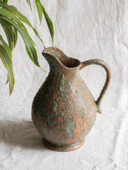 An artisan-made vintage pottery pitcher or jug that purchased in south west France. This piece is wonderful in its earthy tones of brown with a green pattern in relief all over the pitcher and would make a great piece of home decor or addition to a pottery/stoneware collection.