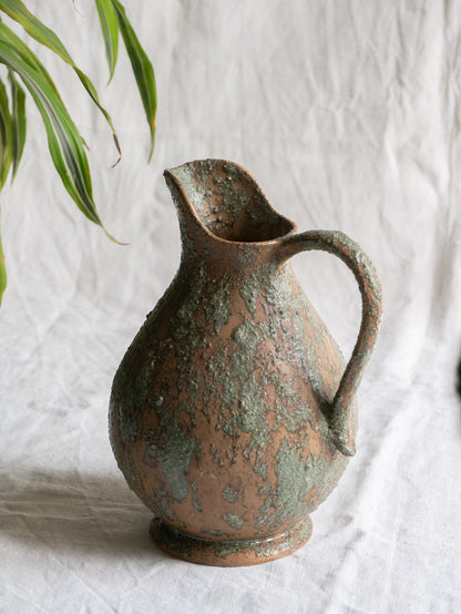An artisan-made vintage pottery pitcher or jug that purchased in south west France. This piece is wonderful in its earthy tones of brown with a green pattern in relief all over the pitcher and would make a great piece of home decor or addition to a pottery/stoneware collection.