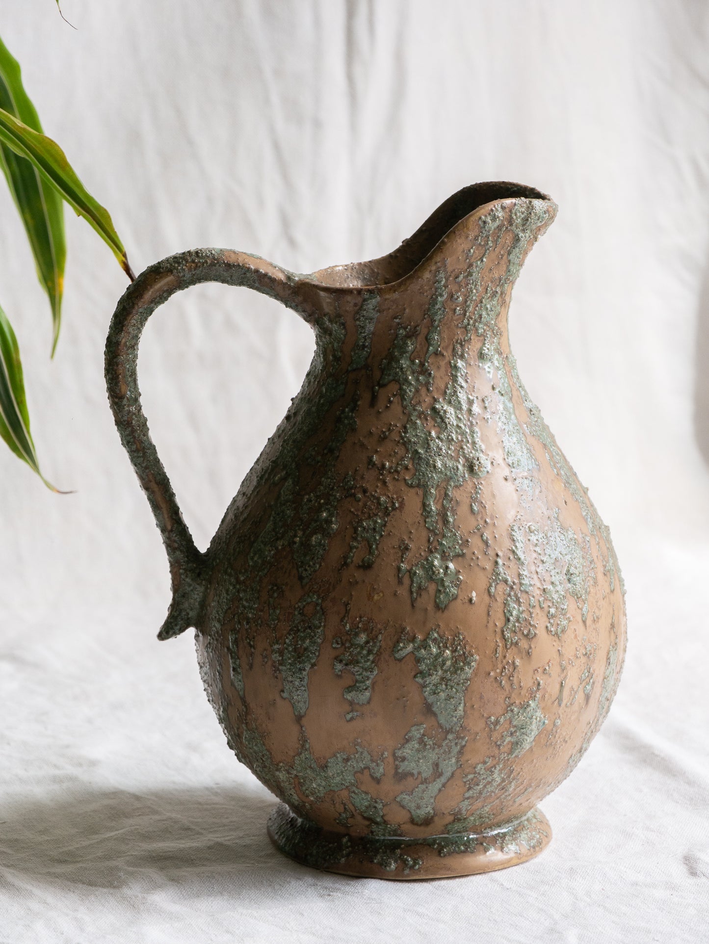 An artisan-made vintage pottery pitcher or jug that purchased in south west France. This piece is wonderful in its earthy tones of brown with a green pattern in relief all over the pitcher and would make a great piece of home decor or addition to a pottery/stoneware collection.