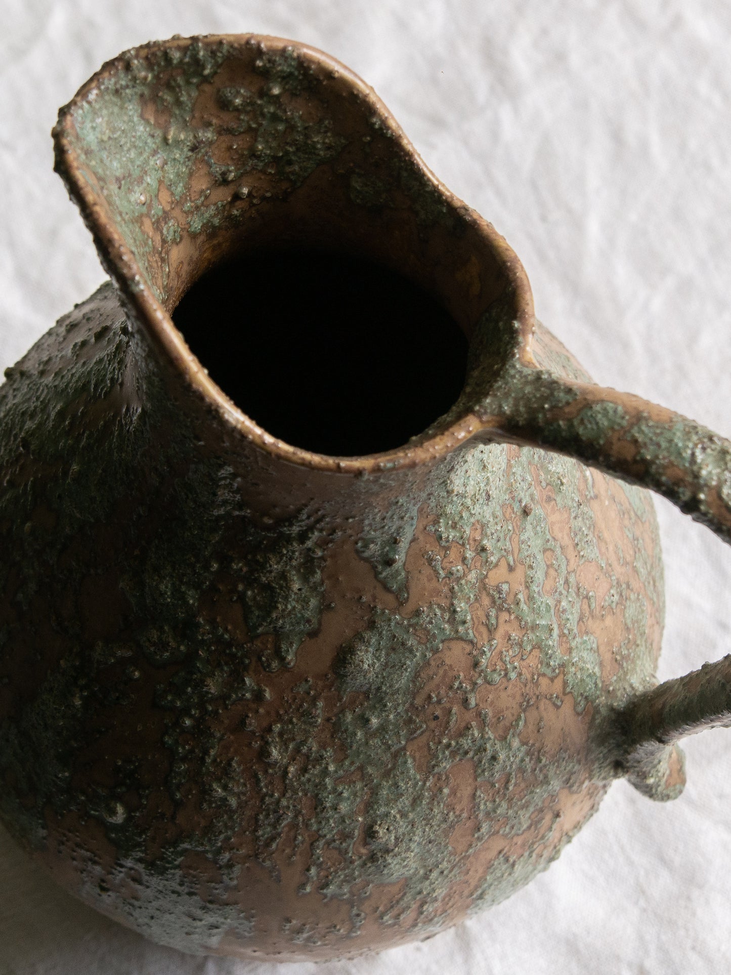 An artisan-made vintage pottery pitcher or jug that purchased in south west France. This piece is wonderful in its earthy tones of brown with a green pattern in relief all over the pitcher and would make a great piece of home decor or addition to a pottery/stoneware collection.