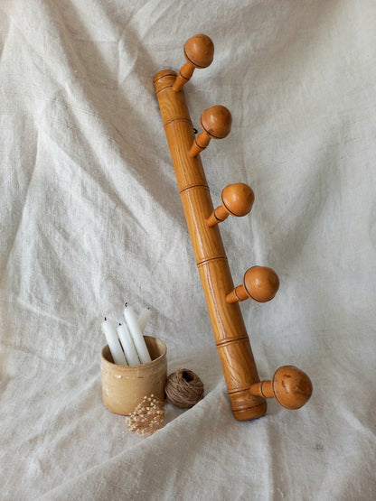 Wooden coat rack with decorative elements on a white fabric background