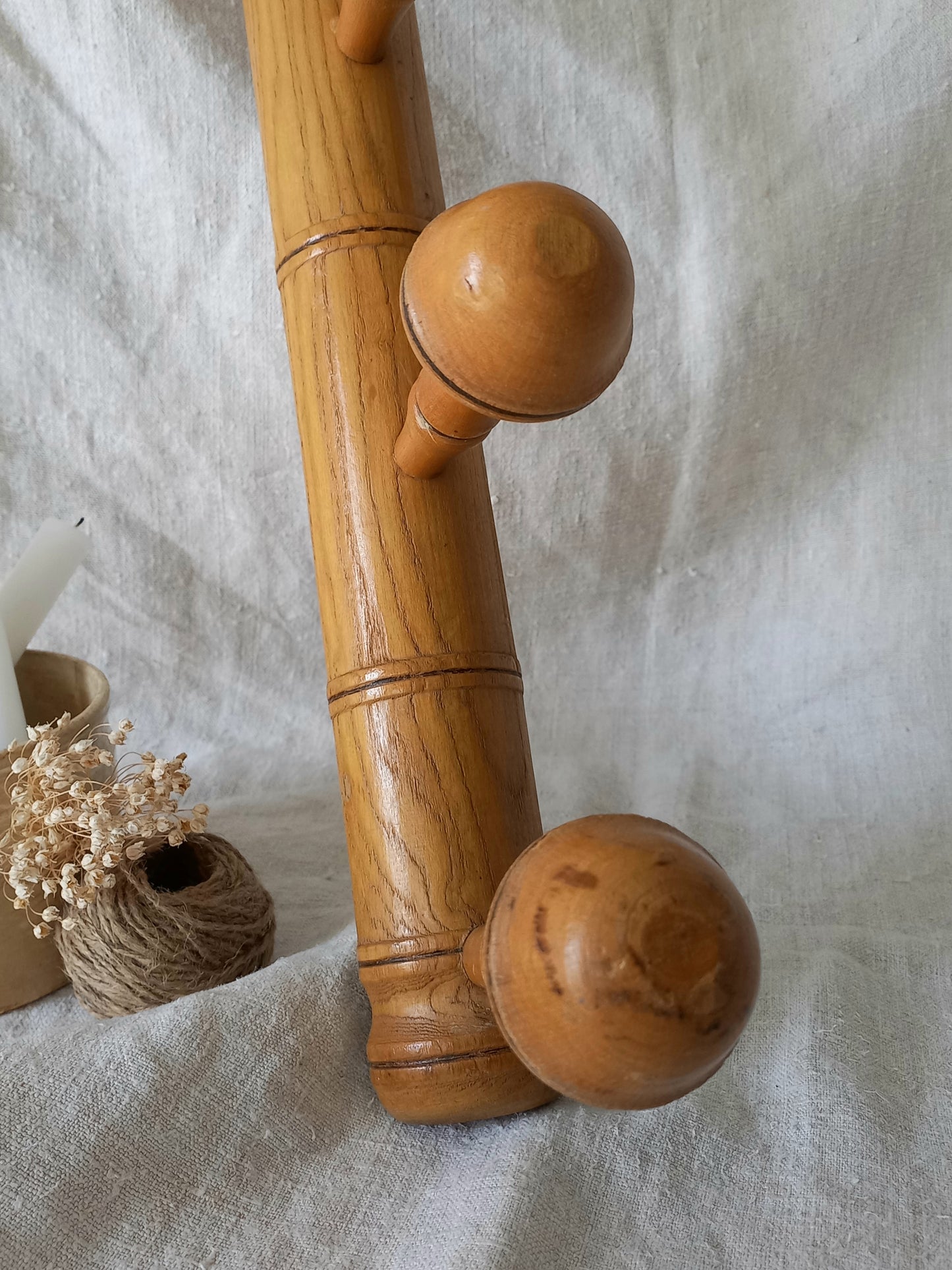 Wooden coat rack with spherical ends on a textured fabric background