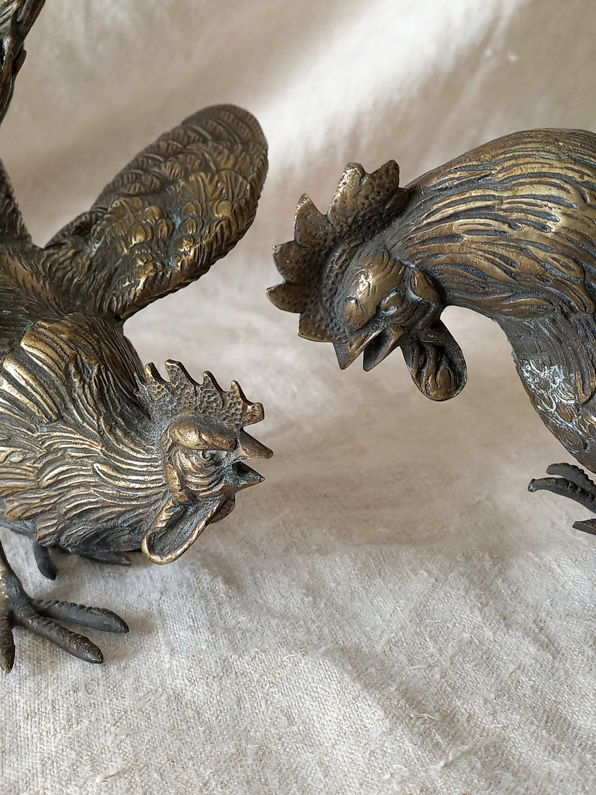 Bronze rooster sculptures on a textured surface