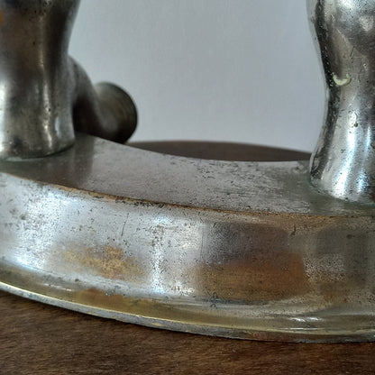 Close-up of a vintage metal faucet on a wooden background with visible wear and tear 