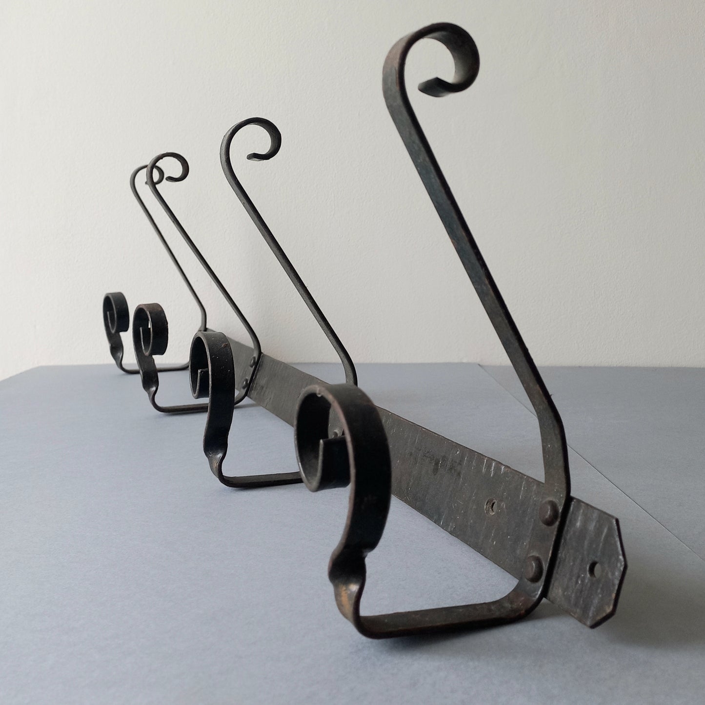 A large French vintage metal coat and hat rack for 4 coats and hats, a hand-made piece that is sturdy and can be screwed directly to your wall using the holes already in the wall bracket. The colour of the coat rack is a pleasing worn satin black with traces of gold showing through in places which give it a nice aged appearance.