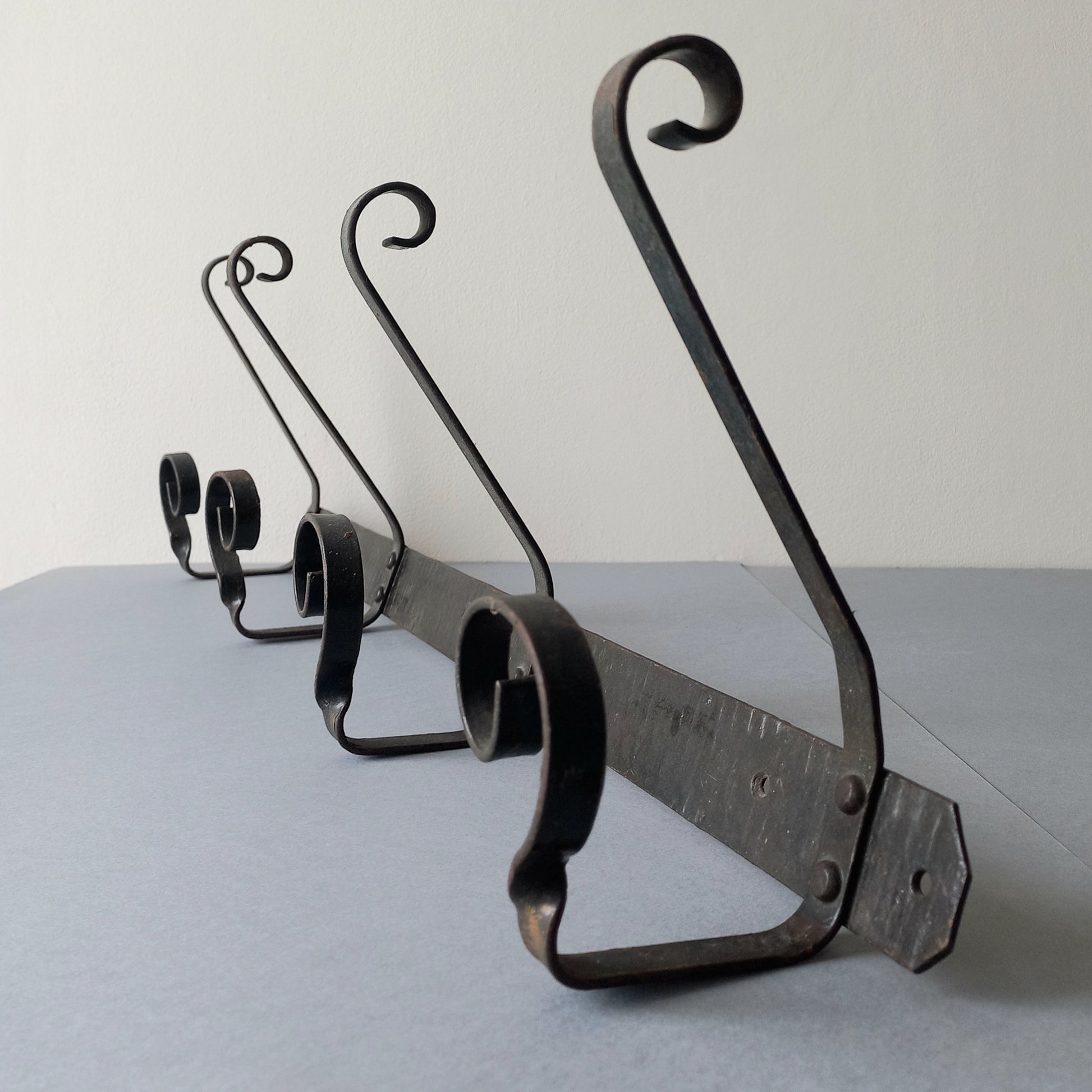 A large French vintage metal coat and hat rack for 4 coats and hats, a hand-made piece that is sturdy and can be screwed directly to your wall using the holes already in the wall bracket. The colour of the coat rack is a pleasing worn satin black with traces of gold showing through in places which give it a nice aged appearance.