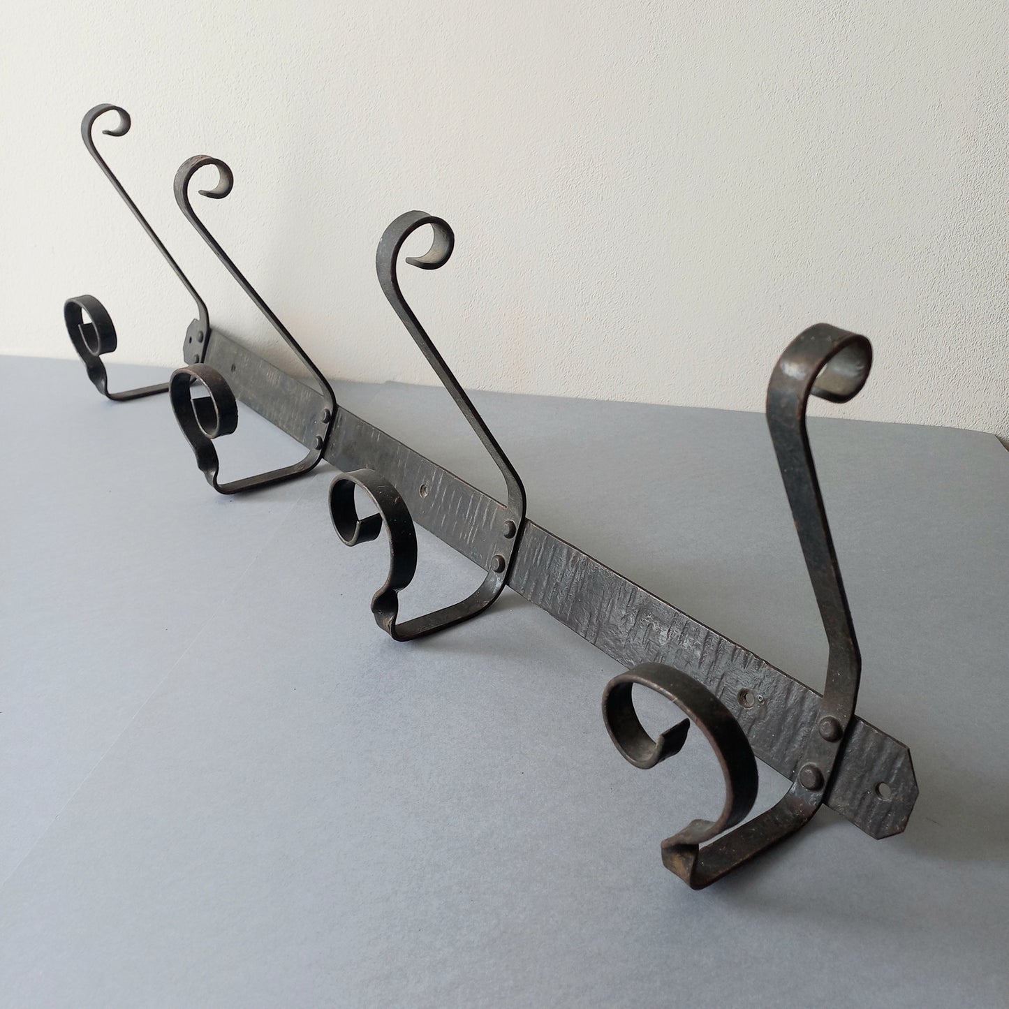 A large French vintage metal coat and hat rack for 4 coats and hats, a hand-made piece that is sturdy and can be screwed directly to your wall using the holes already in the wall bracket. The colour of the coat rack is a pleasing worn satin black with traces of gold showing through in places which give it a nice aged appearance.