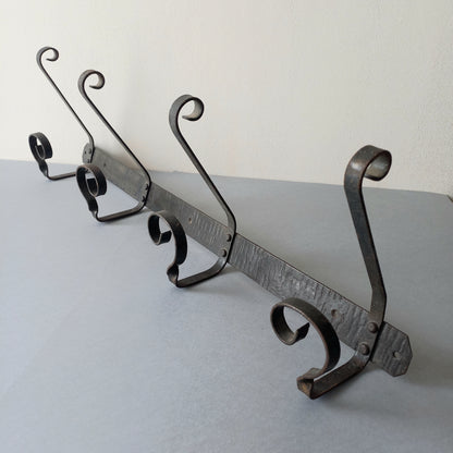 A large French vintage metal coat and hat rack for 4 coats and hats, a hand-made piece that is sturdy and can be screwed directly to your wall using the holes already in the wall bracket. The colour of the coat rack is a pleasing worn satin black with traces of gold showing through in places which give it a nice aged appearance.