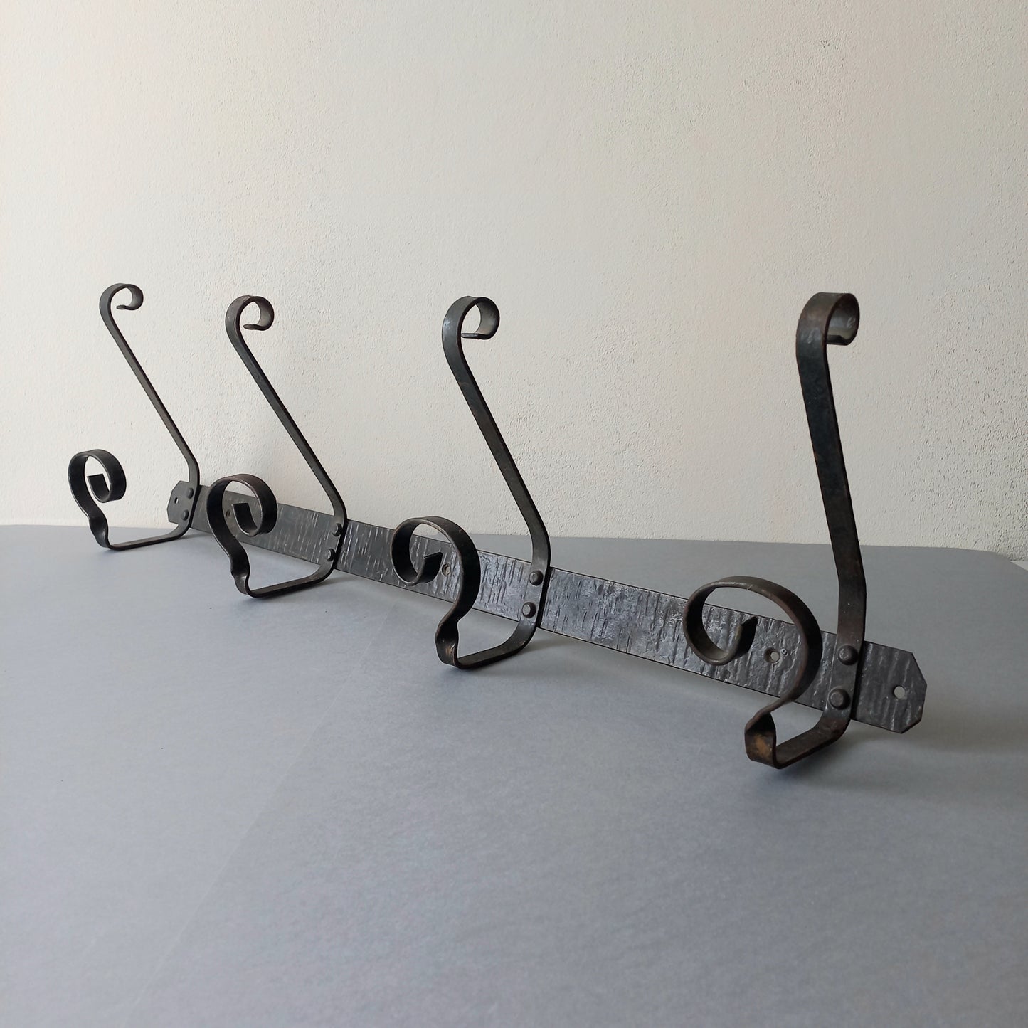 A large French vintage metal coat and hat rack for 4 coats and hats, a hand-made piece that is sturdy and can be screwed directly to your wall using the holes already in the wall bracket. The colour of the coat rack is a pleasing worn satin black with traces of gold showing through in places which give it a nice aged appearance.