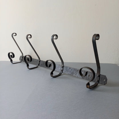 A large French vintage metal coat and hat rack for 4 coats and hats, a hand-made piece that is sturdy and can be screwed directly to your wall using the holes already in the wall bracket. The colour of the coat rack is a pleasing worn satin black with traces of gold showing through in places which give it a nice aged appearance.