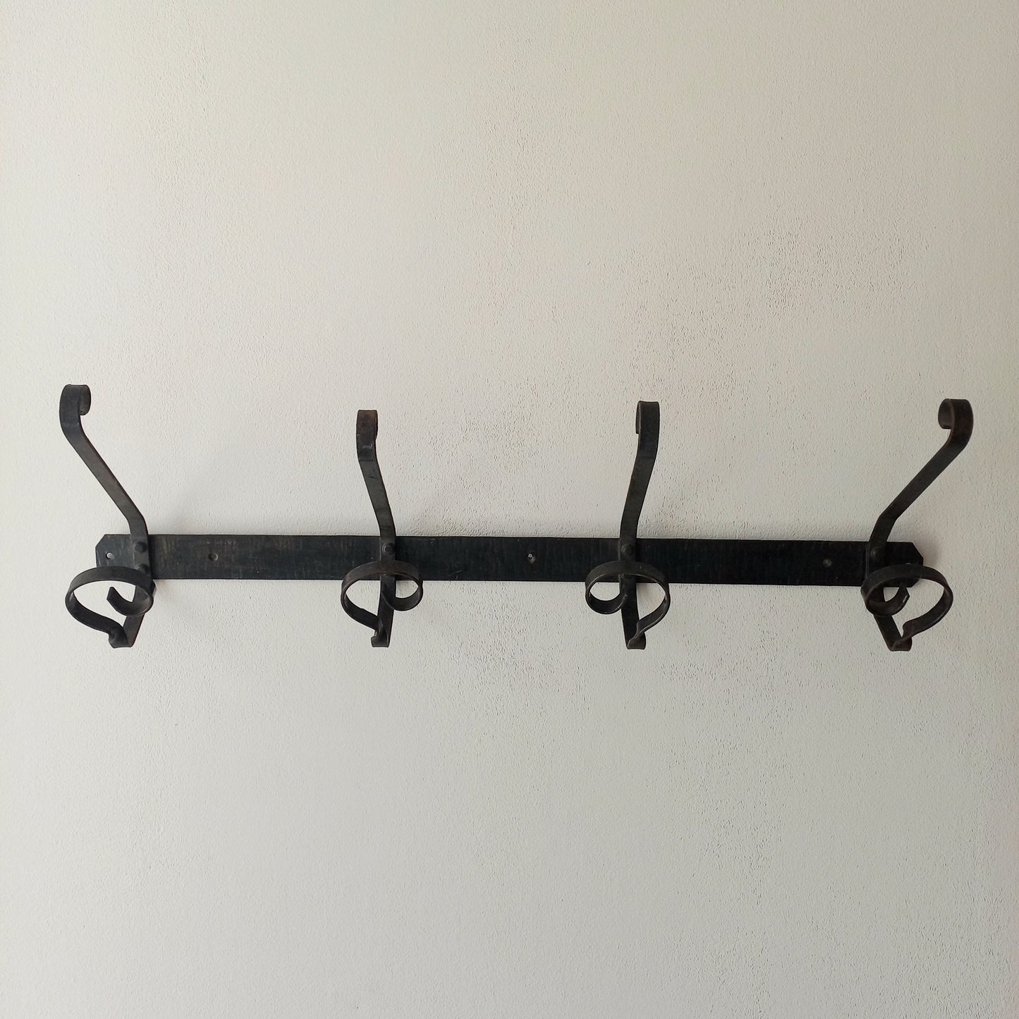 A large French vintage metal coat and hat rack for 4 coats and hats, a hand-made piece that is sturdy and can be screwed directly to your wall using the holes already in the wall bracket. The colour of the coat rack is a pleasing worn satin black with traces of gold showing through in places which give it a nice aged appearance.