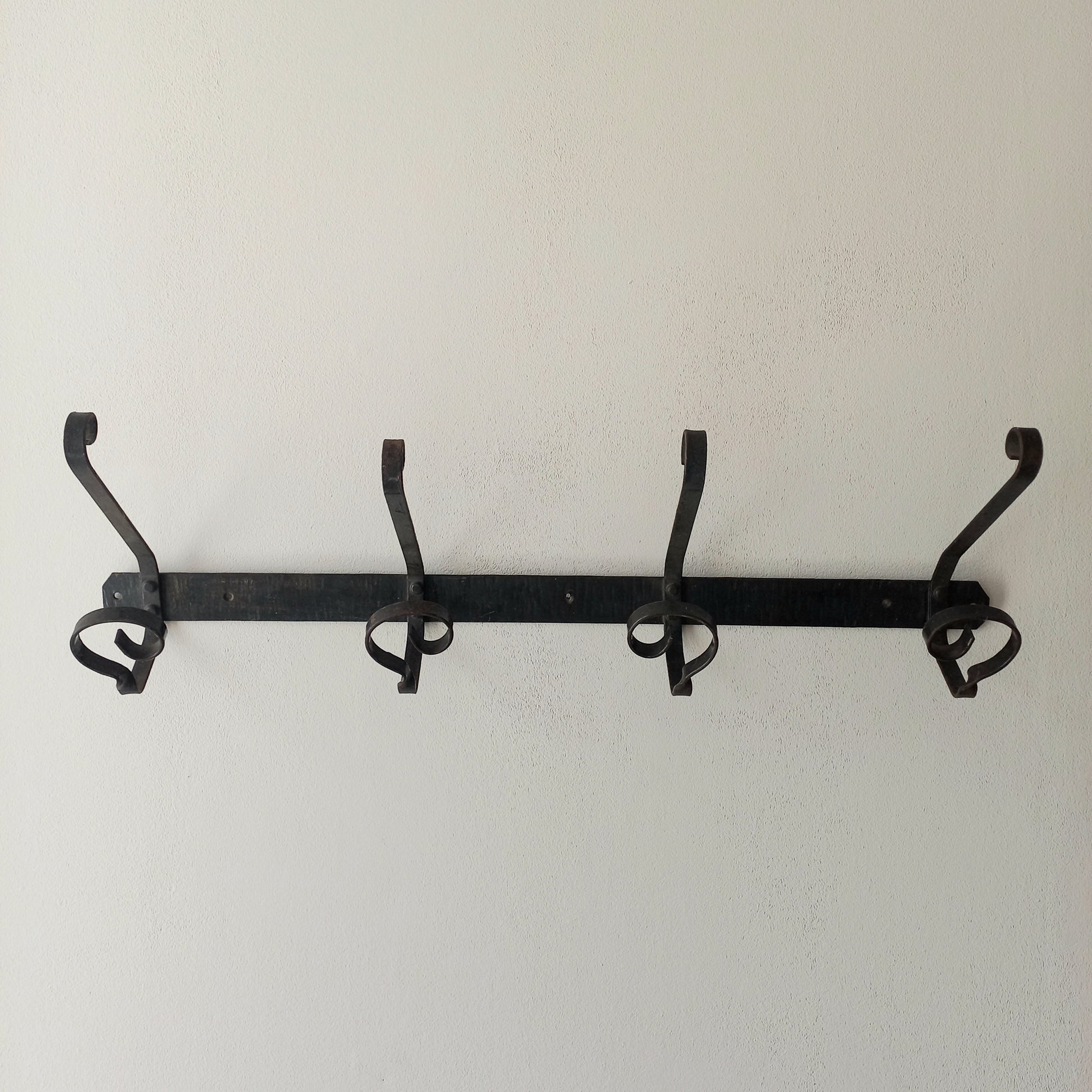 A large French vintage metal coat and hat rack for 4 coats and hats, a hand-made piece that is sturdy and can be screwed directly to your wall using the holes already in the wall bracket. The colour of the coat rack is a pleasing worn satin black with traces of gold showing through in places which give it a nice aged appearance.