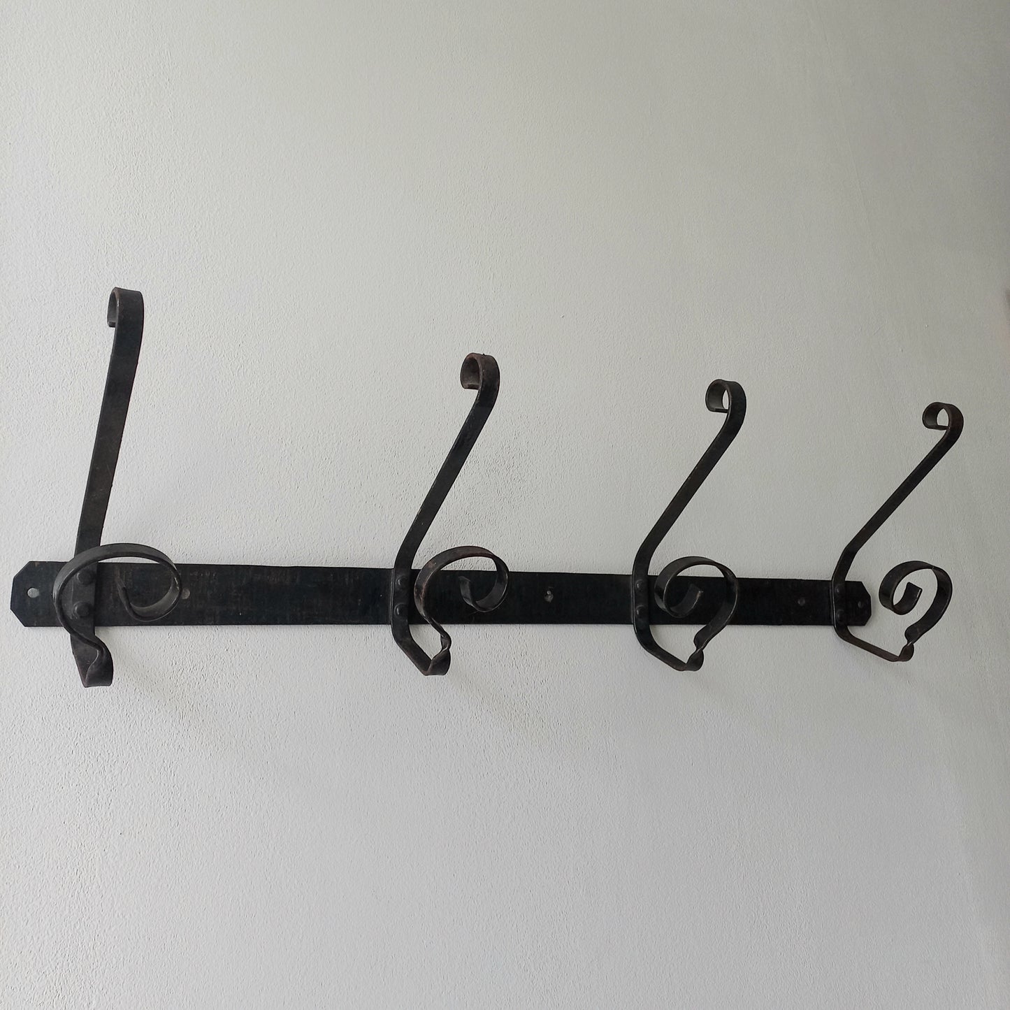 A large French vintage metal coat and hat rack for 4 coats and hats, a hand-made piece that is sturdy and can be screwed directly to your wall using the holes already in the wall bracket. The colour of the coat rack is a pleasing worn satin black with traces of gold showing through in places which give it a nice aged appearance.