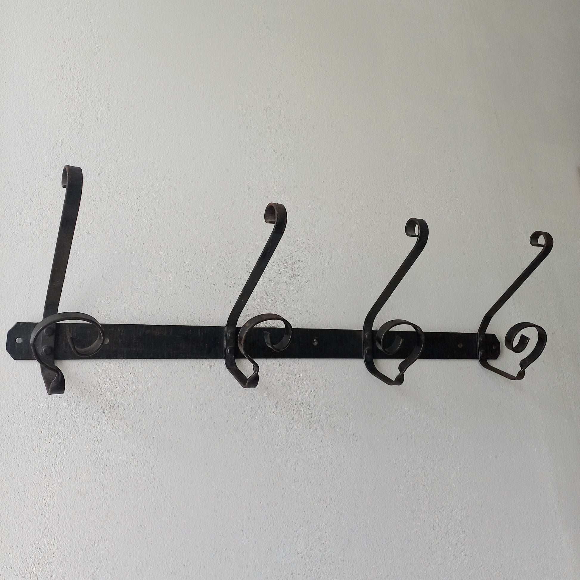 A large French vintage metal coat and hat rack for 4 coats and hats, a hand-made piece that is sturdy and can be screwed directly to your wall using the holes already in the wall bracket. The colour of the coat rack is a pleasing worn satin black with traces of gold showing through in places which give it a nice aged appearance.