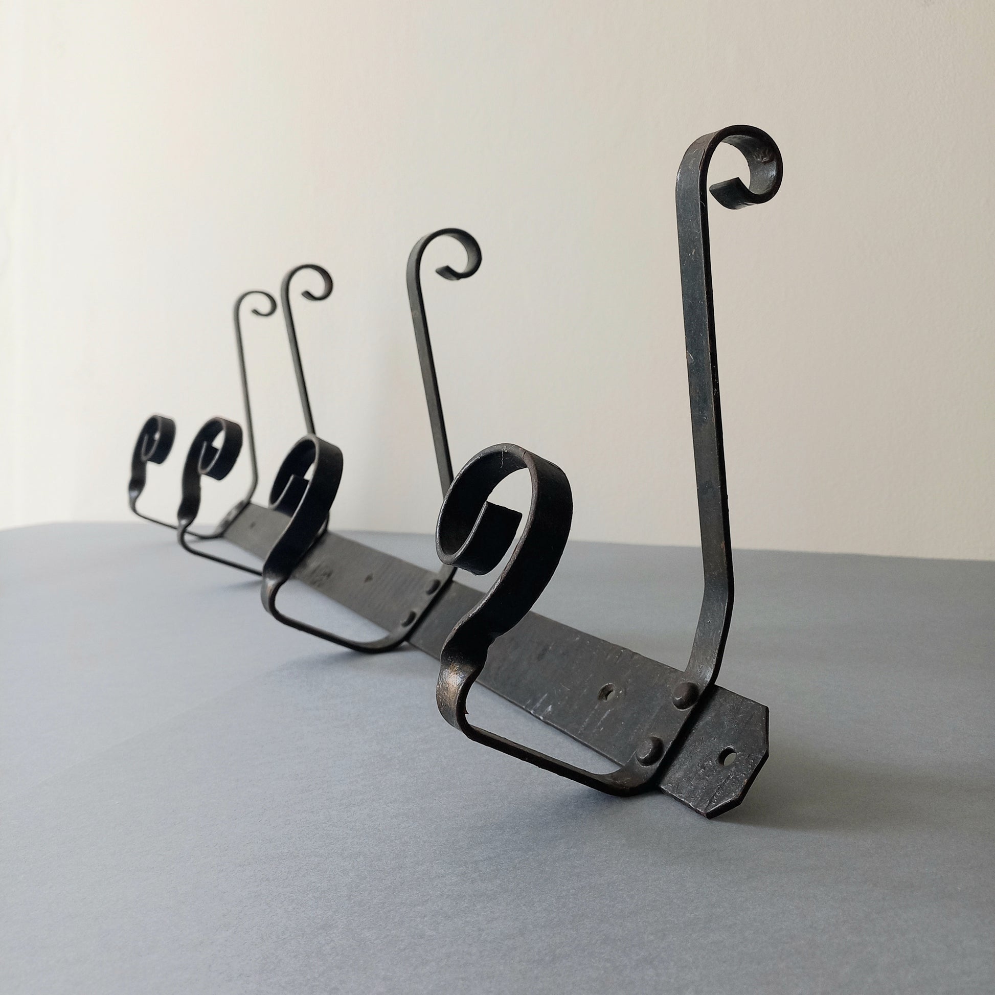 A large French vintage metal coat and hat rack for 4 coats and hats, a hand-made piece that is sturdy and can be screwed directly to your wall using the holes already in the wall bracket. The colour of the coat rack is a pleasing worn satin black with traces of gold showing through in places which give it a nice aged appearance.