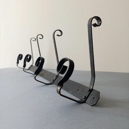 A large French vintage metal coat and hat rack for 4 coats and hats, a hand-made piece that is sturdy and can be screwed directly to your wall using the holes already in the wall bracket. The colour of the coat rack is a pleasing worn satin black with traces of gold showing through in places which give it a nice aged appearance.