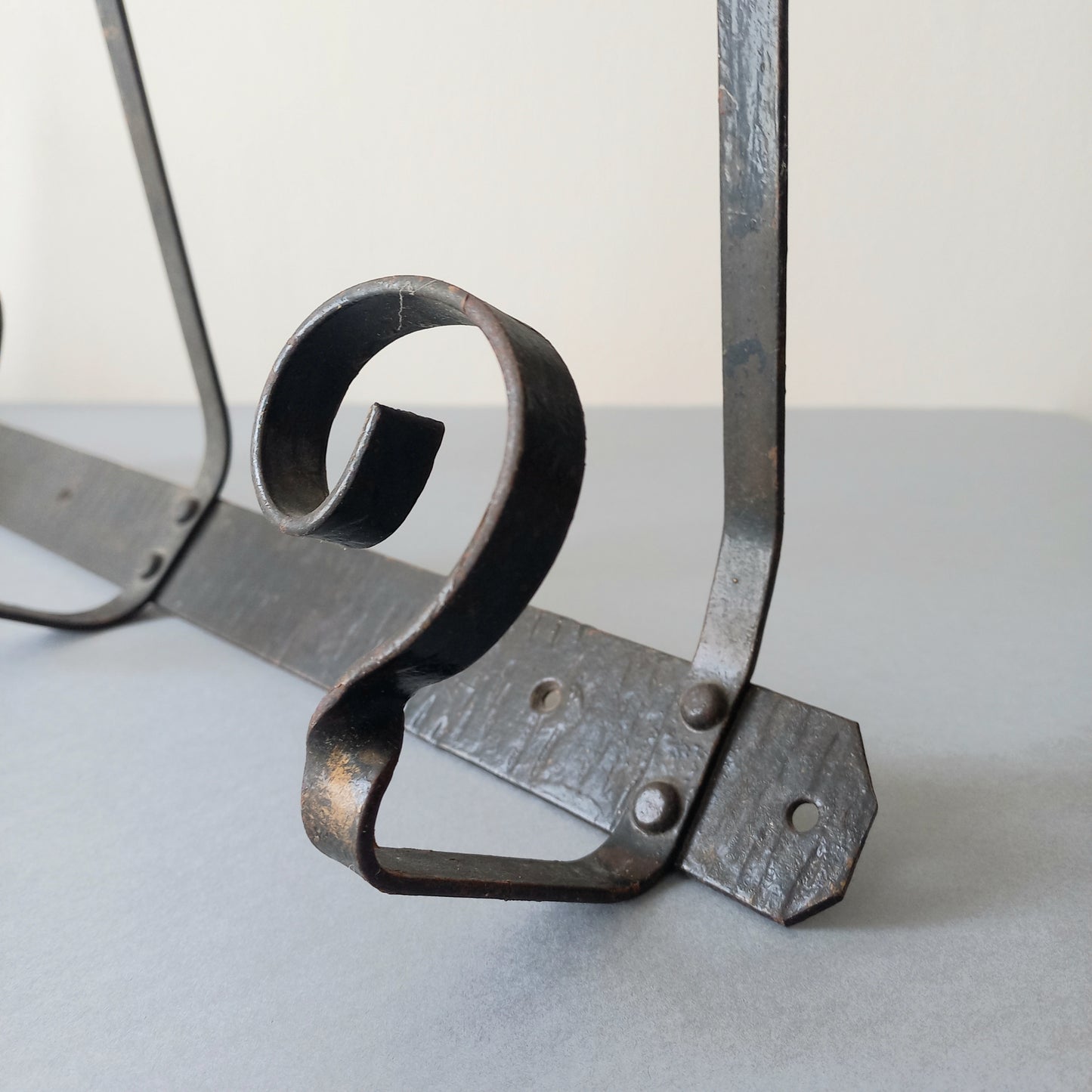A large French vintage metal coat and hat rack for 4 coats and hats, a hand-made piece that is sturdy and can be screwed directly to your wall using the holes already in the wall bracket. The colour of the coat rack is a pleasing worn satin black with traces of gold showing through in places which give it a nice aged appearance.