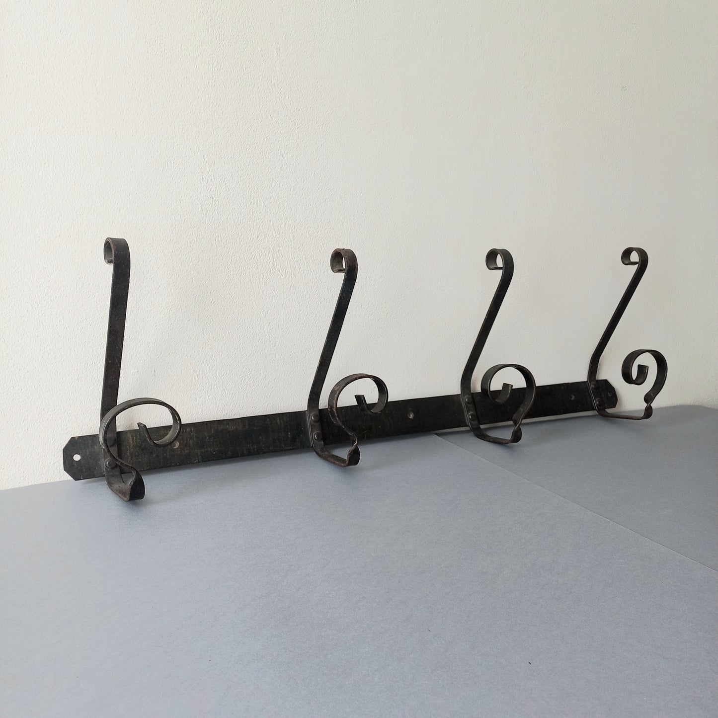A large French vintage metal coat and hat rack for 4 coats and hats, a hand-made piece that is sturdy and can be screwed directly to your wall using the holes already in the wall bracket. The colour of the coat rack is a pleasing worn satin black with traces of gold showing through in places which give it a nice aged appearance.