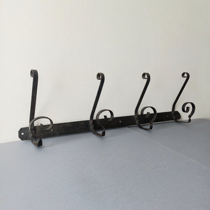 A large French vintage metal coat and hat rack for 4 coats and hats, a hand-made piece that is sturdy and can be screwed directly to your wall using the holes already in the wall bracket. The colour of the coat rack is a pleasing worn satin black with traces of gold showing through in places which give it a nice aged appearance.