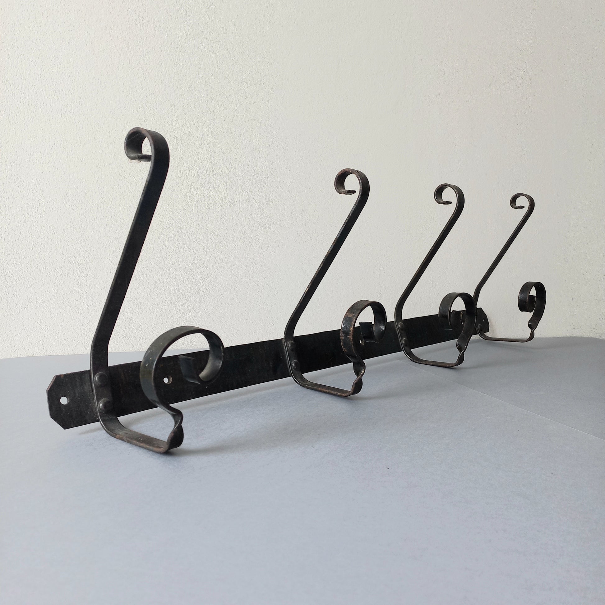 A large French vintage metal coat and hat rack for 4 coats and hats, a hand-made piece that is sturdy and can be screwed directly to your wall using the holes already in the wall bracket. The colour of the coat rack is a pleasing worn satin black with traces of gold showing through in places which give it a nice aged appearance.