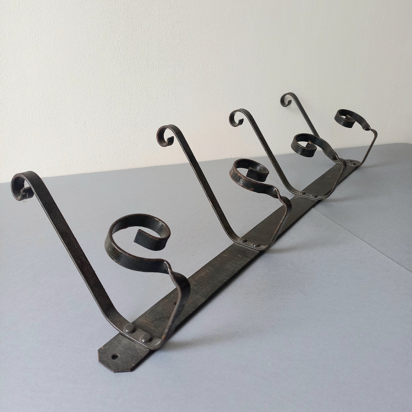 A large French vintage metal coat and hat rack for 4 coats and hats, a hand-made piece that is sturdy and can be screwed directly to your wall using the holes already in the wall bracket. The colour of the coat rack is a pleasing worn satin black with traces of gold showing through in places which give it a nice aged appearance.