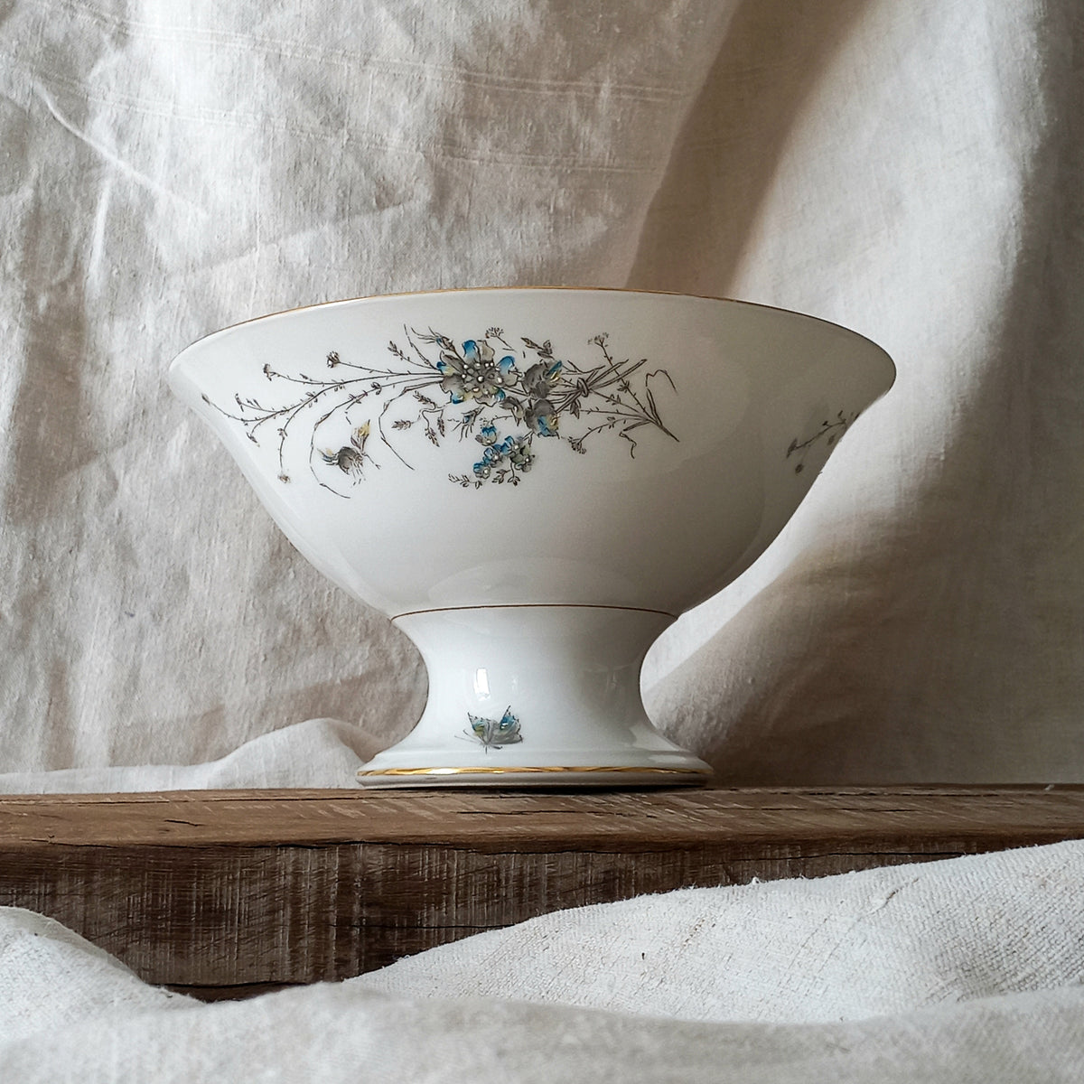 Stunning vintage porcelain compote purchased in south west France.

This beautiful piece is a quality 'footed' fruit bowl with a good weight and absolutely gorgeous floral and butterfly decoration with hand-painted details in relief.