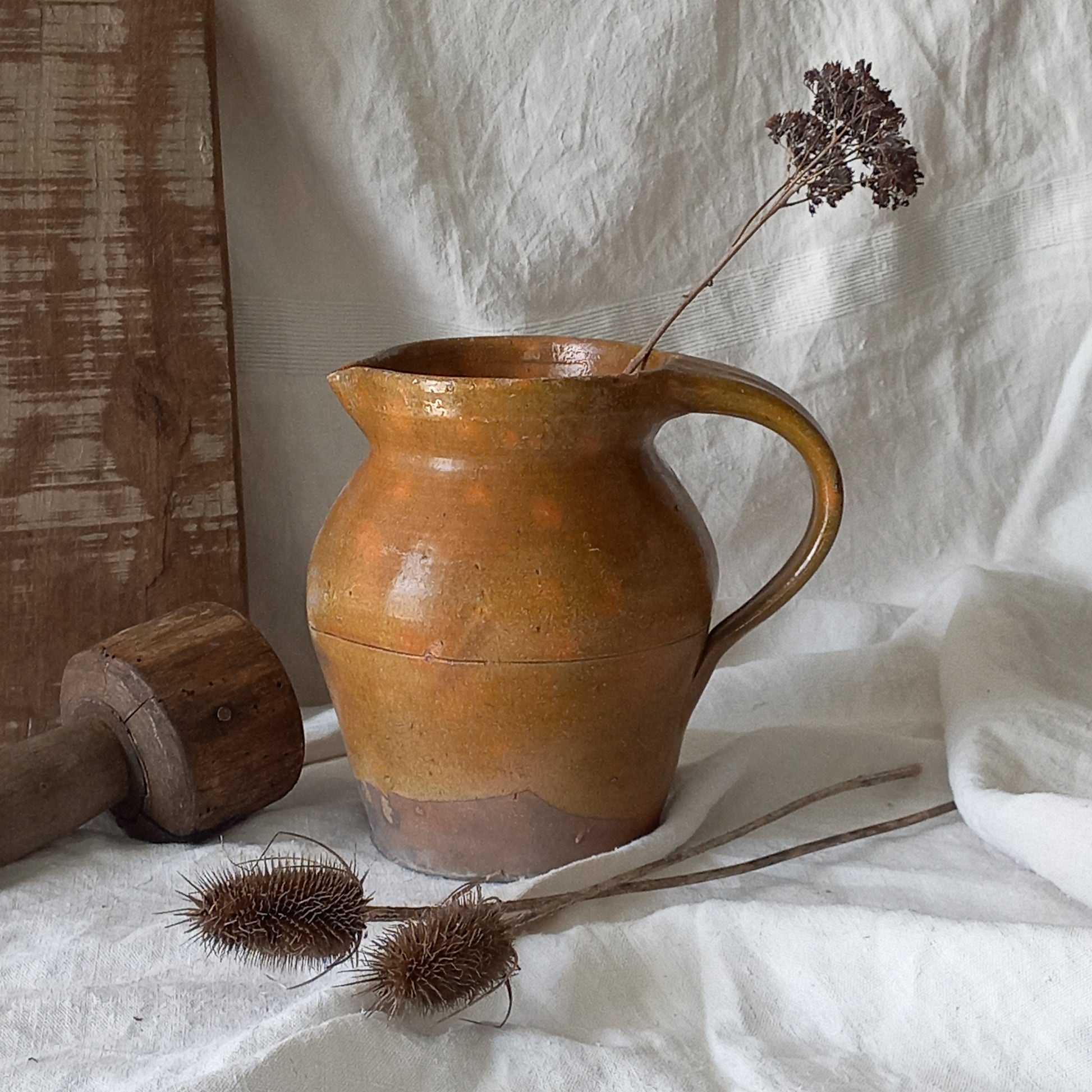 A rustic antique pottery glazed jug, a charming hand-made piece in a lovely shade of ochre with subtle traces of green. Underneath is the French maker's mark.

This piece of stoneware will look wonderful in any interior, particularly those of a rustic, country and farmhouse nature.