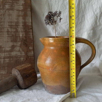 A rustic antique pottery glazed jug, a charming hand-made piece in a lovely shade of ochre with subtle traces of green. Underneath is the French maker's mark.

This piece of stoneware will look wonderful in any interior, particularly those of a rustic, country and farmhouse nature.