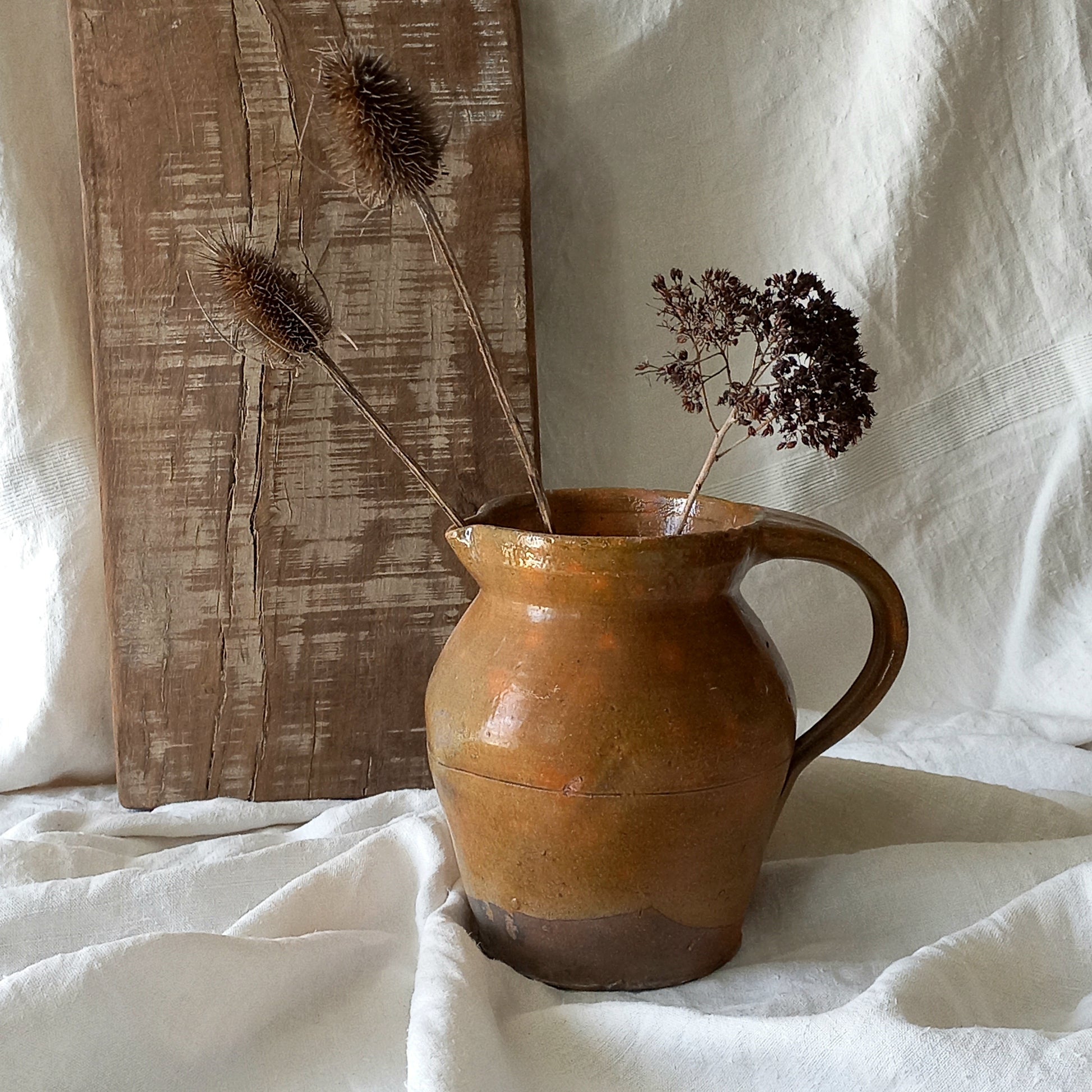 A rustic antique pottery glazed jug, a charming hand-made piece in a lovely shade of ochre with subtle traces of green. Underneath is the French maker's mark.

This piece of stoneware will look wonderful in any interior, particularly those of a rustic, country and farmhouse nature.