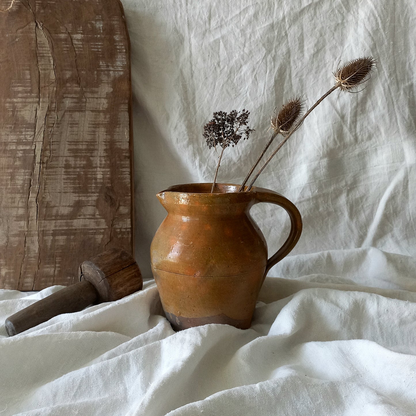 A rustic antique pottery glazed jug, a charming hand-made piece in a lovely shade of ochre with subtle traces of green. Underneath is the French maker's mark.

This piece of stoneware will look wonderful in any interior, particularly those of a rustic, country and farmhouse nature.