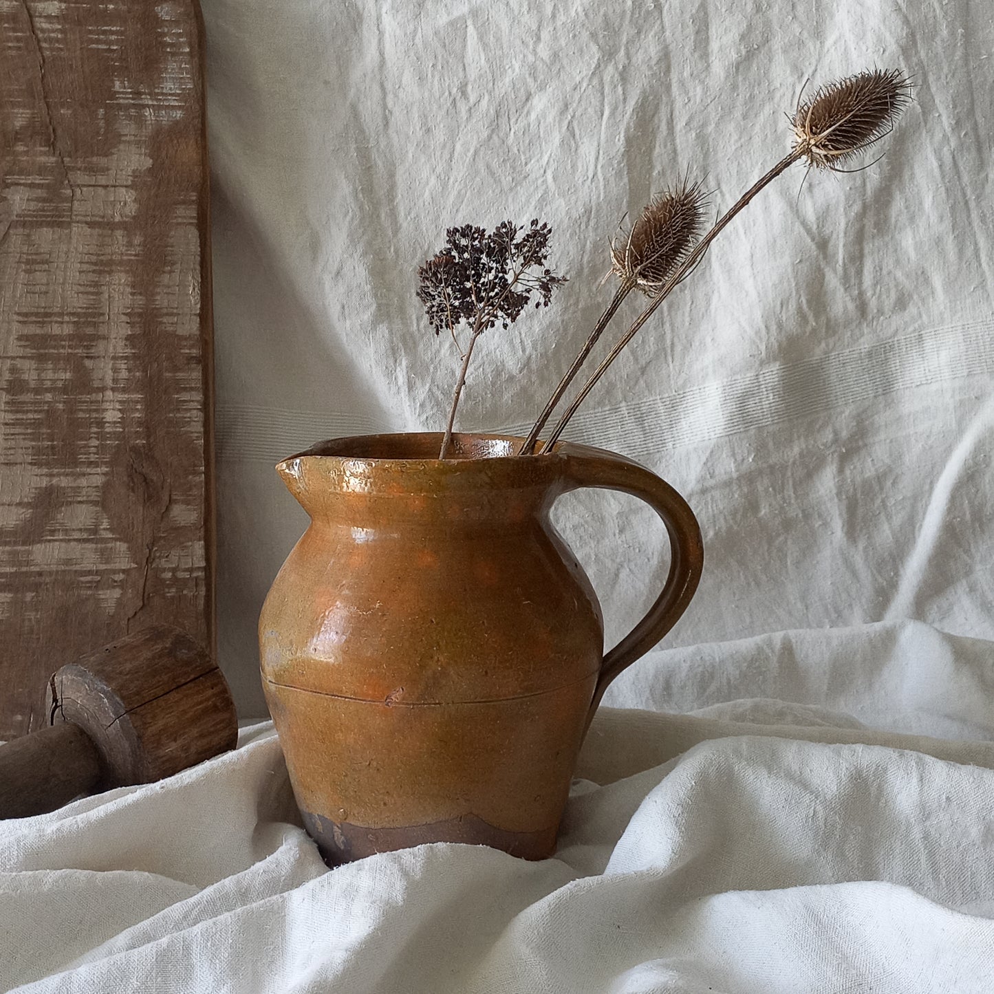 A rustic antique pottery glazed jug, a charming hand-made piece in a lovely shade of ochre with subtle traces of green. Underneath is the French maker's mark.

This piece of stoneware will look wonderful in any interior, particularly those of a rustic, country and farmhouse nature.