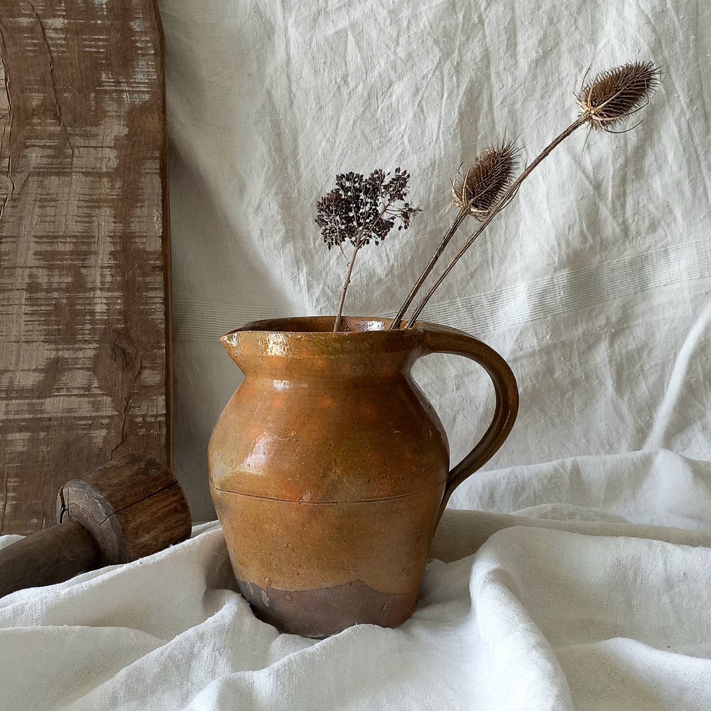 A rustic antique pottery glazed jug, a charming hand-made piece in a lovely shade of ochre with subtle traces of green. Underneath is the French maker's mark.

This piece of stoneware will look wonderful in any interior, particularly those of a rustic, country and farmhouse nature.