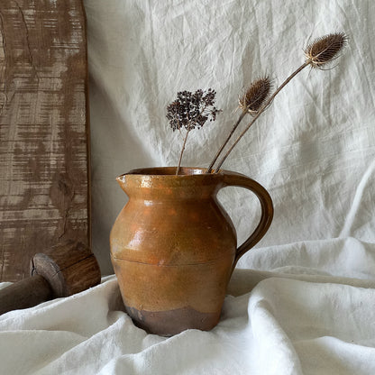 A rustic antique pottery glazed jug, a charming hand-made piece in a lovely shade of ochre with subtle traces of green. Underneath is the French maker's mark.

This piece of stoneware will look wonderful in any interior, particularly those of a rustic, country and farmhouse nature.