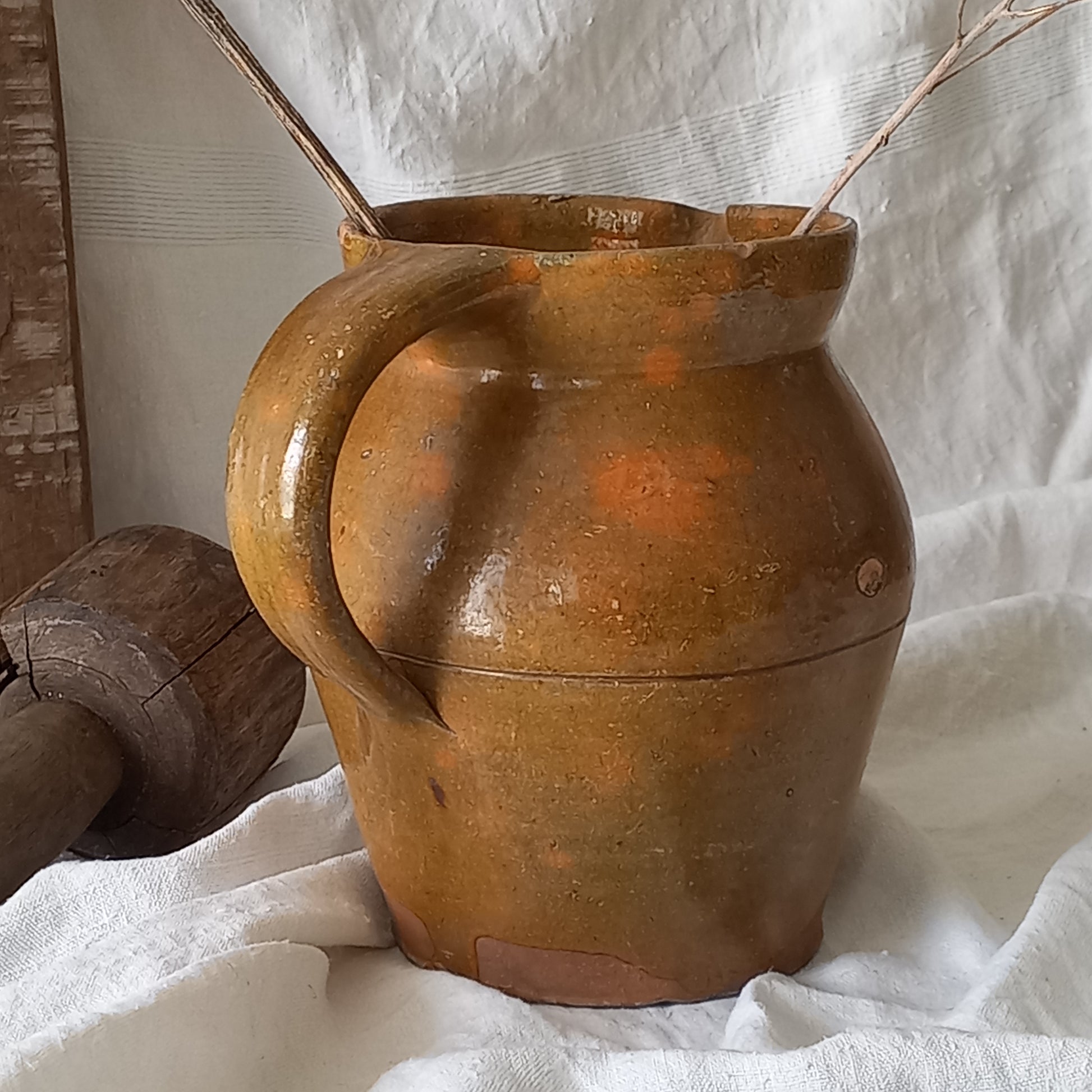 A rustic antique pottery glazed jug, a charming hand-made piece in a lovely shade of ochre with subtle traces of green. Underneath is the French maker's mark.

This piece of stoneware will look wonderful in any interior, particularly those of a rustic, country and farmhouse nature.