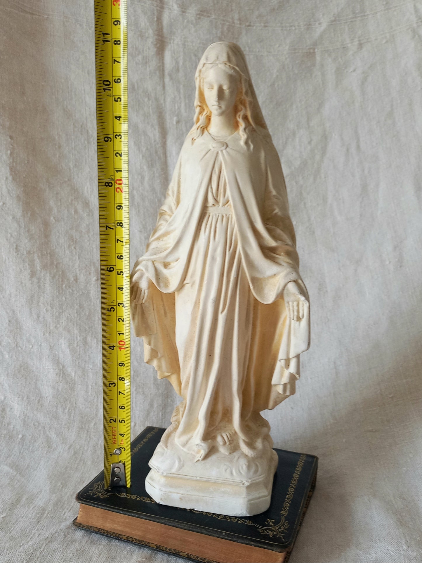 French vintage religious Madonna figurine made from plaster with a tape measure for reference.