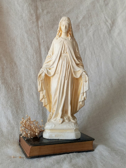 Statue of a draped figure on a textured fabric background