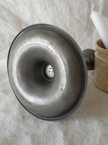 pewter candlestick holder on a textured white fabric background
