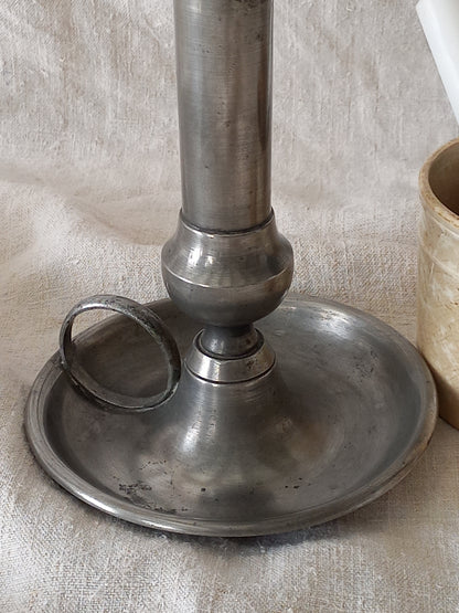 pewter candlestick holder on a textured white fabric background