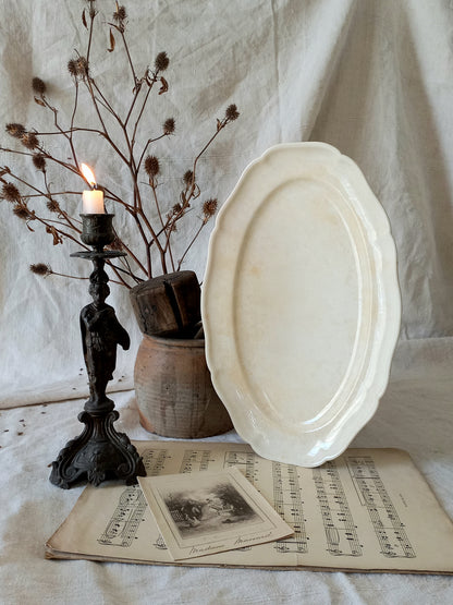 A beautiful vintage oval ironstone serving plate with decorative edges in a time-worn creamy white with super tea-staining that gives it that shabby chic finish many of us desire.