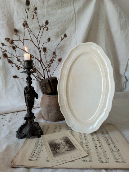 A beautiful vintage oval ironstone serving plate with decorative edges in a time-worn creamy white with super tea-staining that gives it that shabby chic finish many of us desire.
