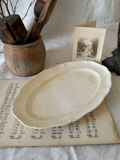 A beautiful vintage oval ironstone serving plate with decorative edges in a time-worn creamy white with super tea-staining that gives it that shabby chic finish many of us desire.