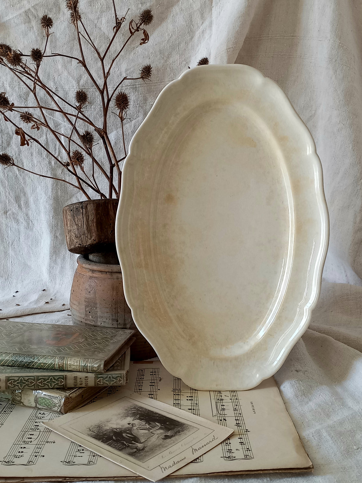 A beautiful vintage oval ironstone serving plate with decorative edges in a time-worn creamy white with super tea-staining that gives it that shabby chic finish many of us desire.