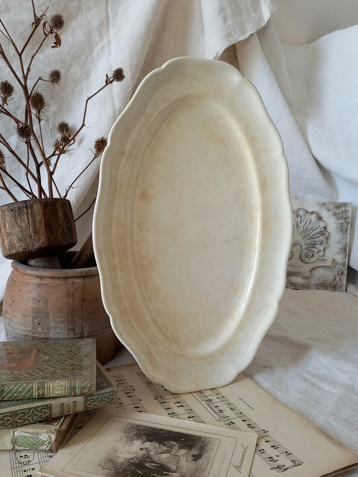 A beautiful vintage oval ironstone serving plate with decorative edges in a time-worn creamy white with super tea-staining that gives it that shabby chic finish many of us desire.