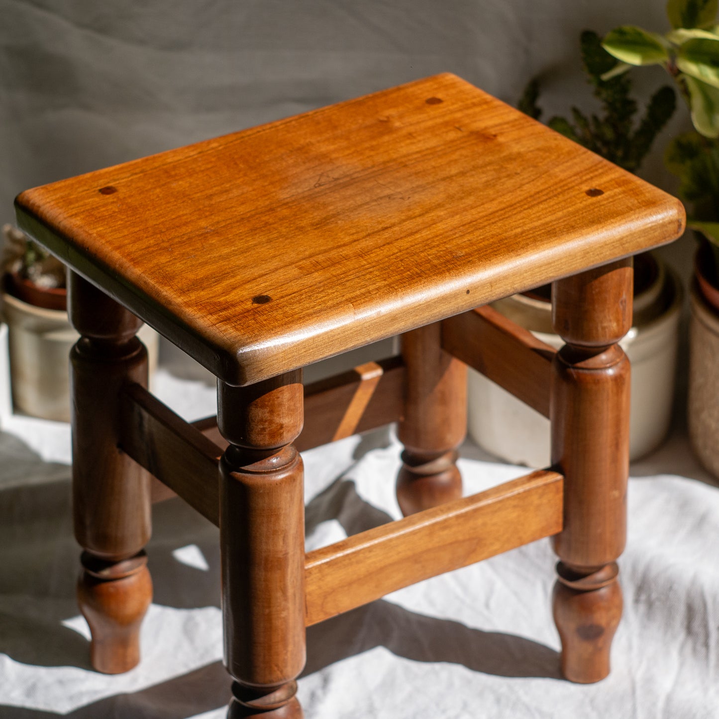 A handsome vintage French wooden stool in a lovely shade of honey-coloured brown. This old stool is very solid and would make a great plant stand (we currently use one on our desk as a plant stand and it looks great!) and many other decorative possibilities.
