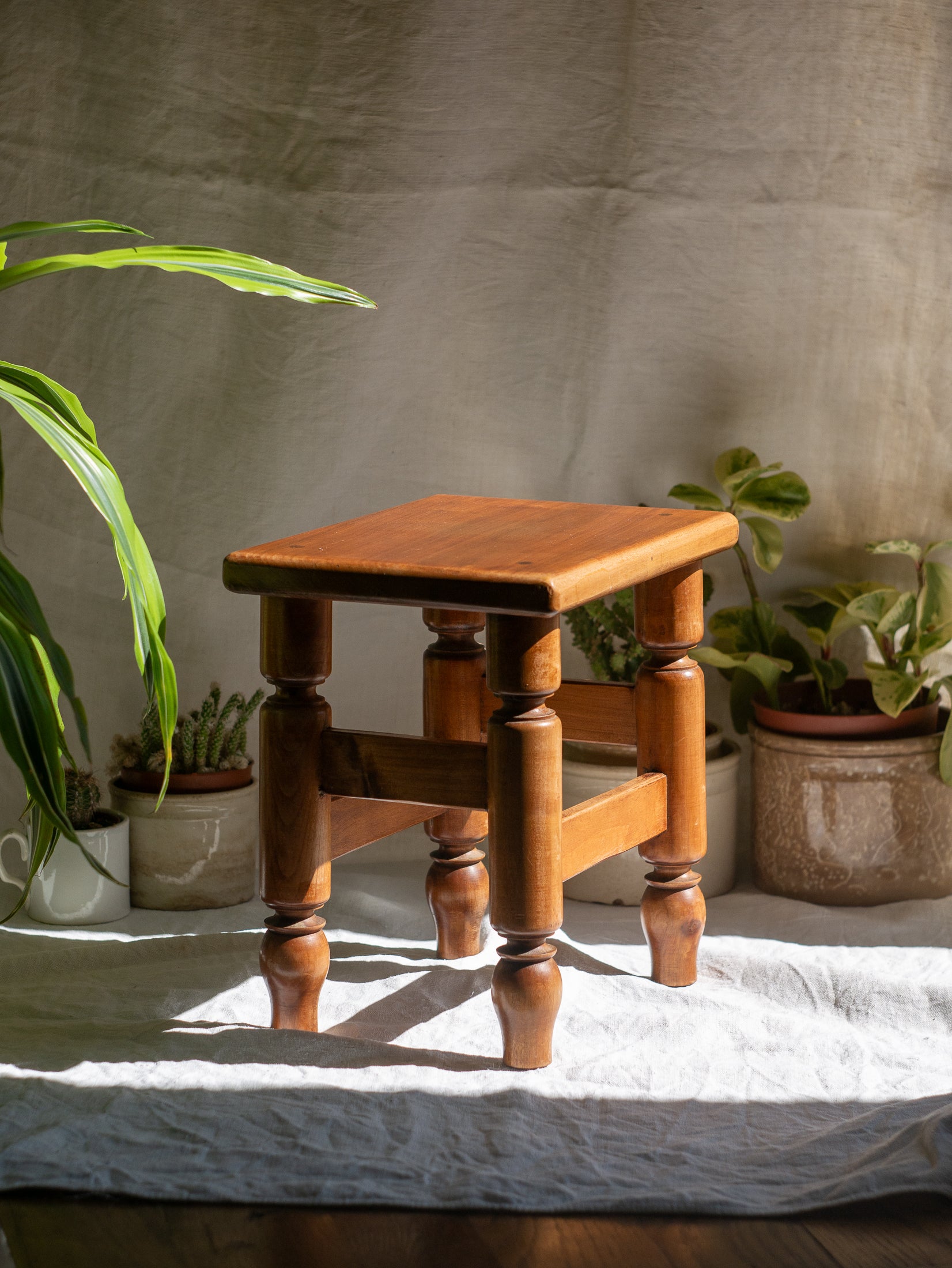 A handsome vintage French wooden stool in a lovely shade of honey-coloured brown. This old stool is very solid and would make a great plant stand (we currently use one on our desk as a plant stand and it looks great!) and many other decorative possibilities.