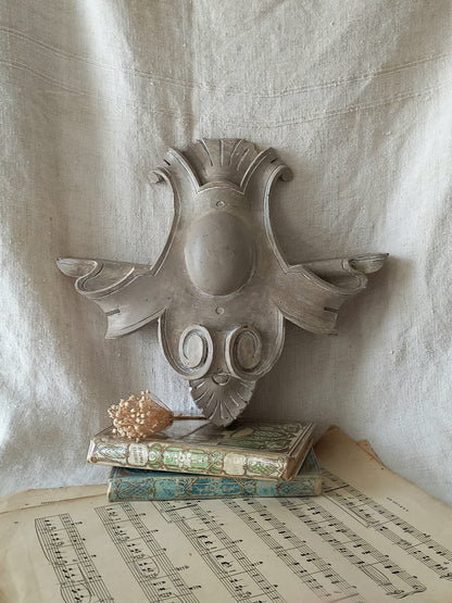A French antique decorative carved wooden pediment that has been tastefully painted and worn to give an attractive shabby chic finish.