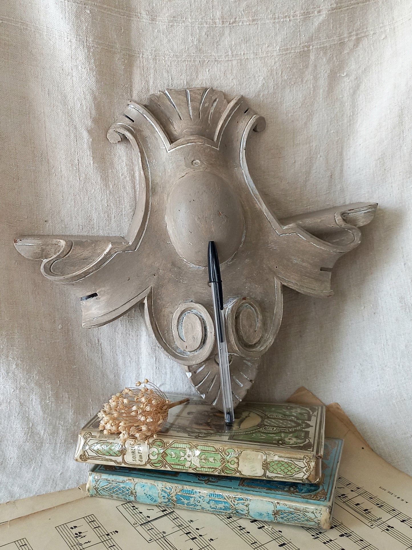 A French antique decorative carved wooden pediment that has been tastefully painted and worn to give an attractive shabby chic finish.