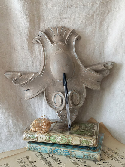 A French antique decorative carved wooden pediment that has been tastefully painted and worn to give an attractive shabby chic finish.